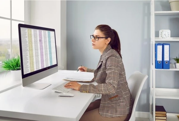 Mujer haciendo una planilla de calculo en Excel, ejemplo idóneo para hacer una Capacitar en Excel