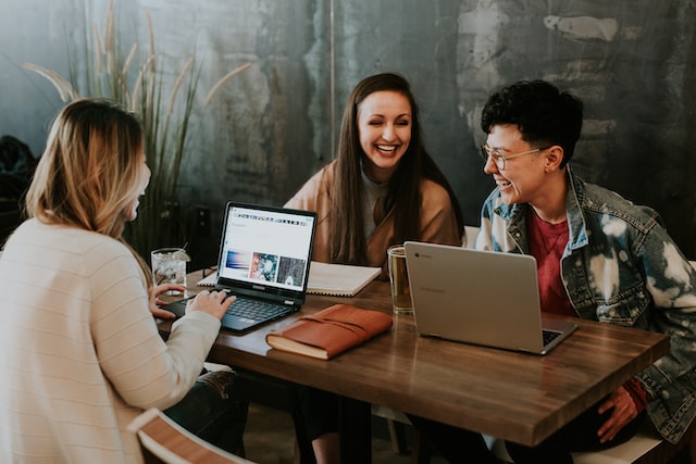 Personas trabajando y riendo en un buen clima laboral