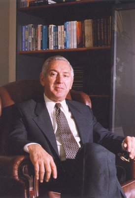 The author of "Management of Human Talent", Idalberto Chiavenato sitting with a shelf with his works behind him.
