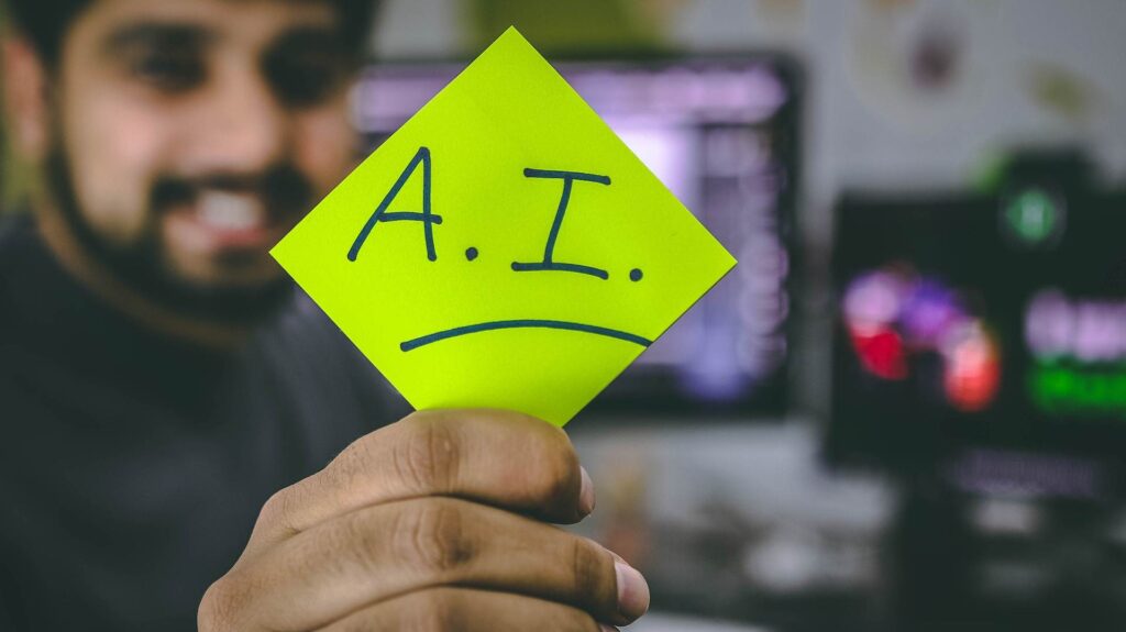 Hombre sostiene un post it con el acrónimo de inteligencia artificial para capacitaciones