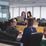 Trabajadores hablando en una oficina sobre capacitaciones en línea
