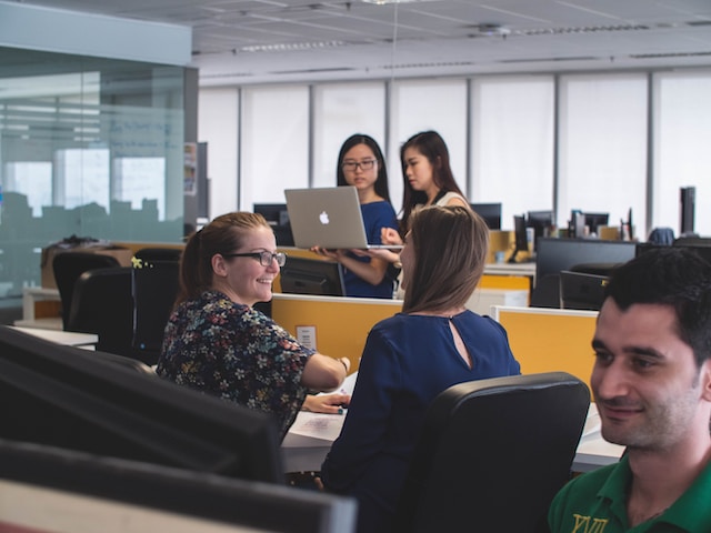 Workers talking in an office about online training