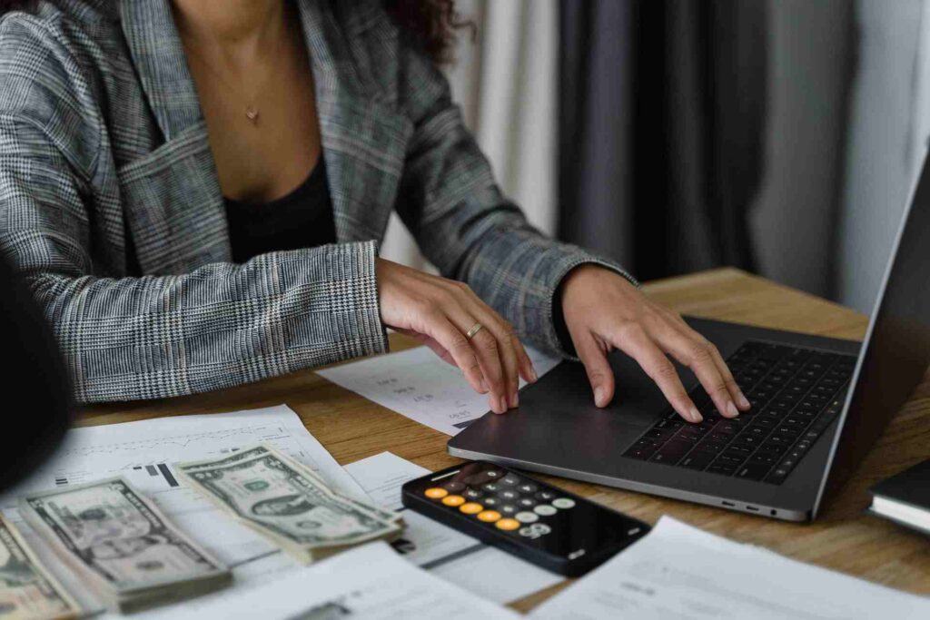 woman typing on her computer doing calculations in Excel formulas and functions